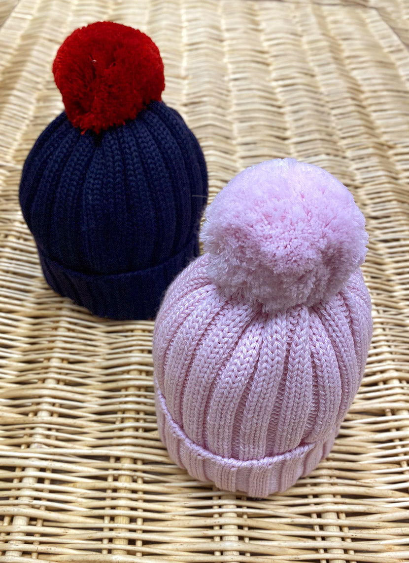 Una Bambina Con Un Cappello A Maglia Con Una Gran Pompa Di Pelo Sciarpa E Maglione Isolato Su Fondo Bianco 169557196